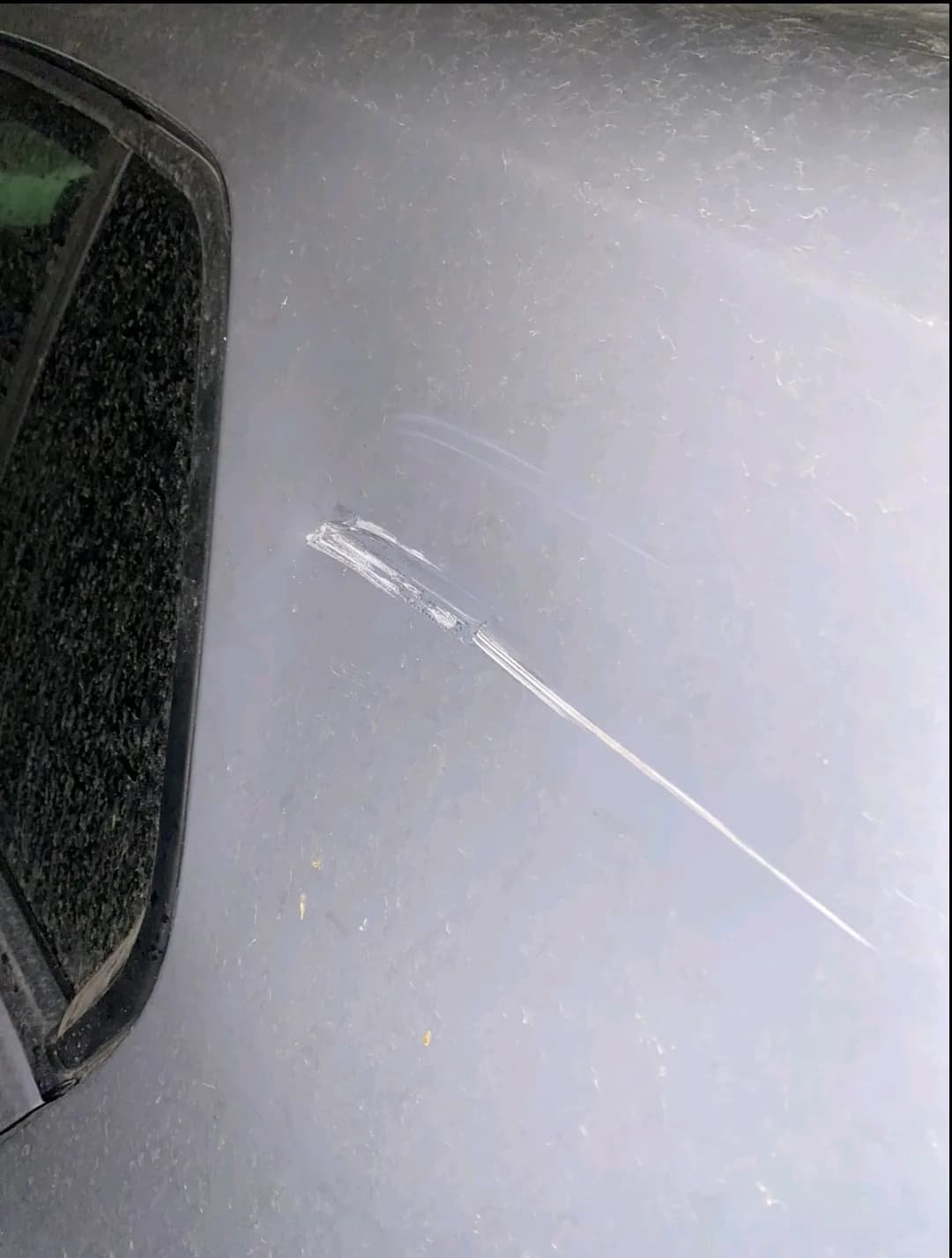 Before: deep scratch + dent on the left quarter panel